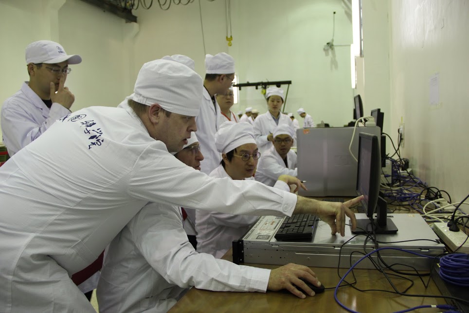 Chinese and ESA team members work on installation of SCCO onto the Shijian-10 retrievable satellite.