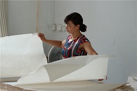 A female worker checks sheets of Xuan paper at a paper mill in Jingxian county, Anhui province.